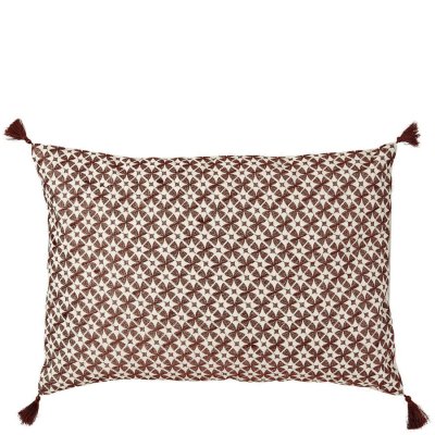 Avlång kudde i naturfärg med mönster i rost, koppar och tofsar i hörnen